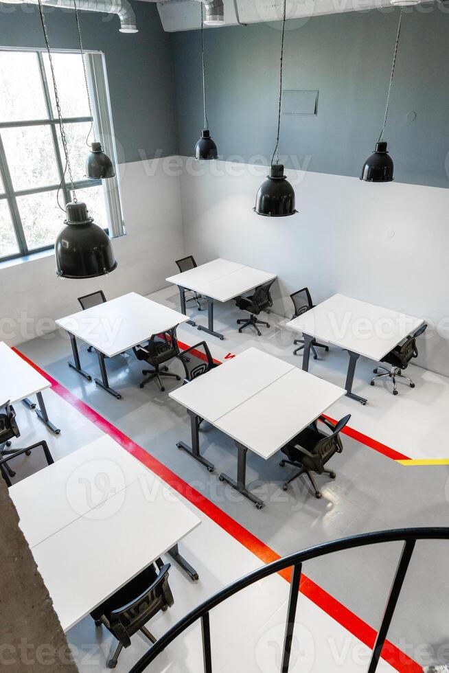 Modern office workspace featuring tables and chairs in a bright, minimalist design photo