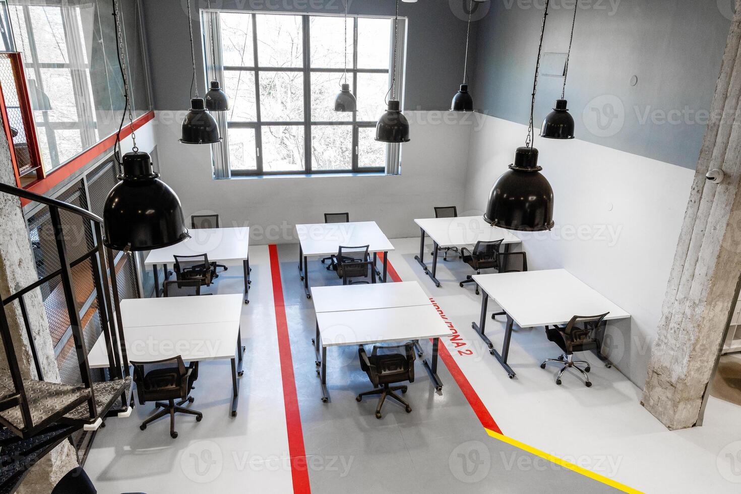 Modern workspace with multiple desks and large windows creating a bright atmosphere for collaboration photo