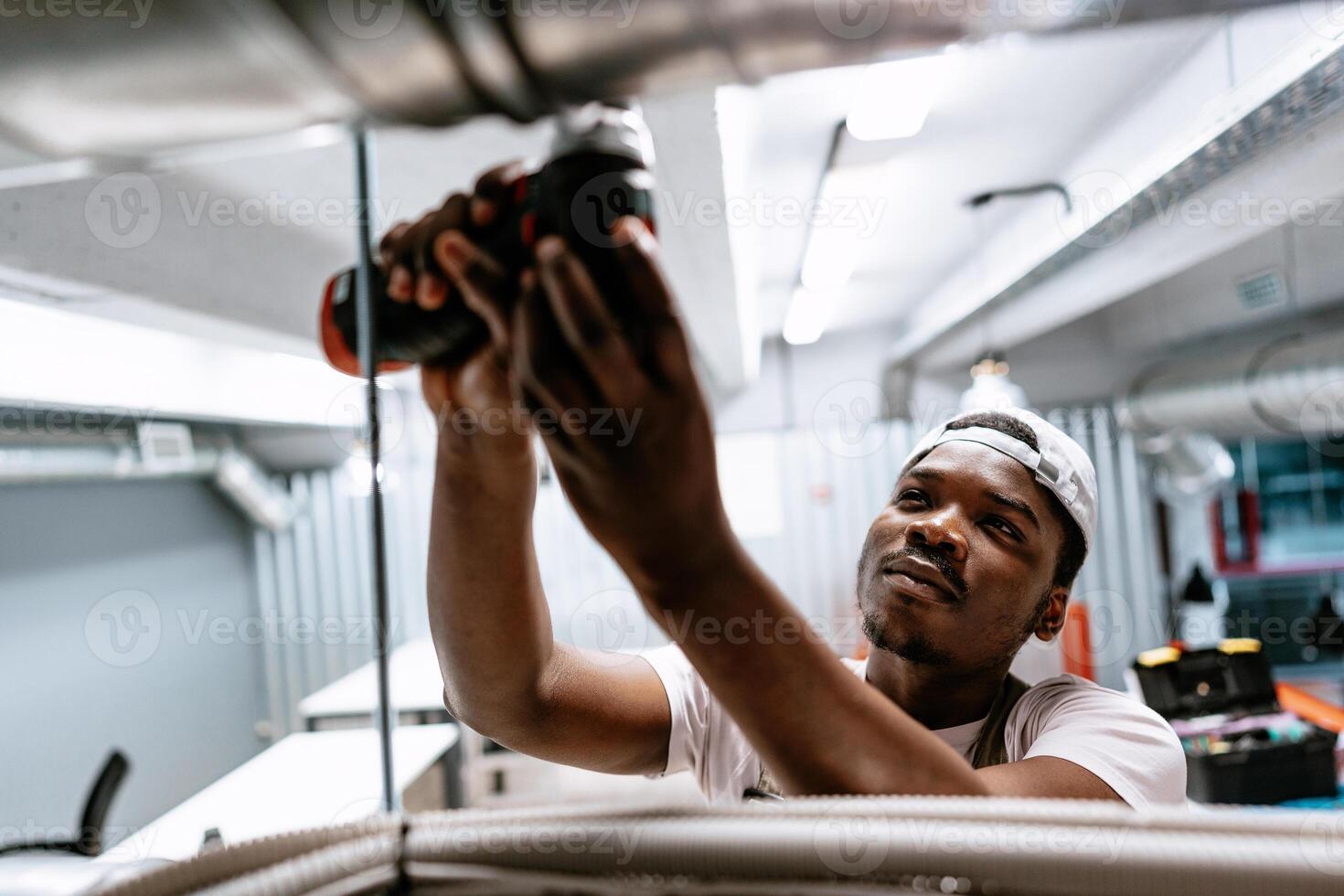 Electrician works with power tools in modern commercial building near city center after hours photo