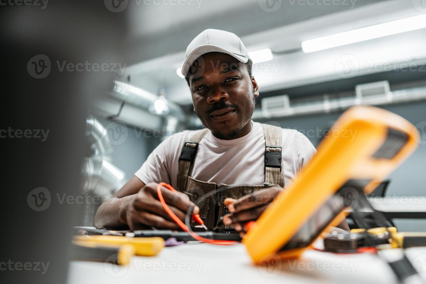 Skilled technician working on electrical equipment in a modern workshop setting photo