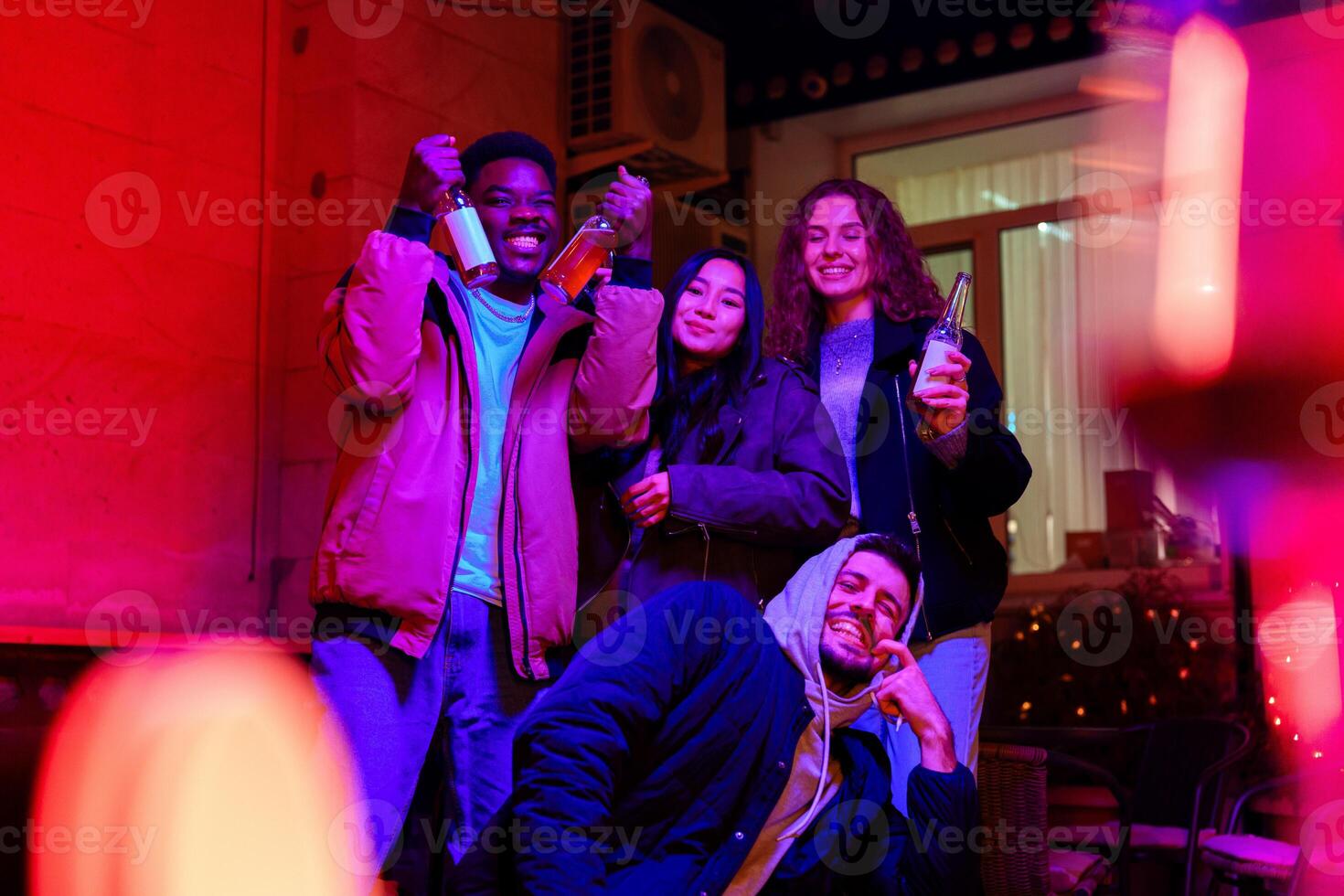 Friends celebrate at a lively gathering in a warmly decorated space at night photo
