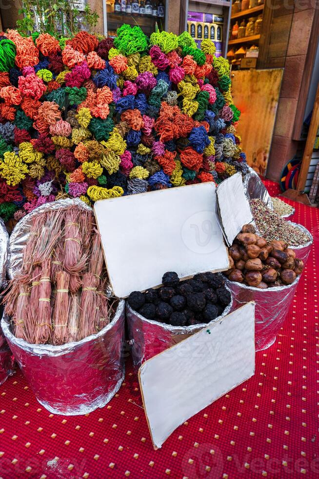 Colorful spices and herbs displayed at a bustling market in Morocco during the afternoon photo