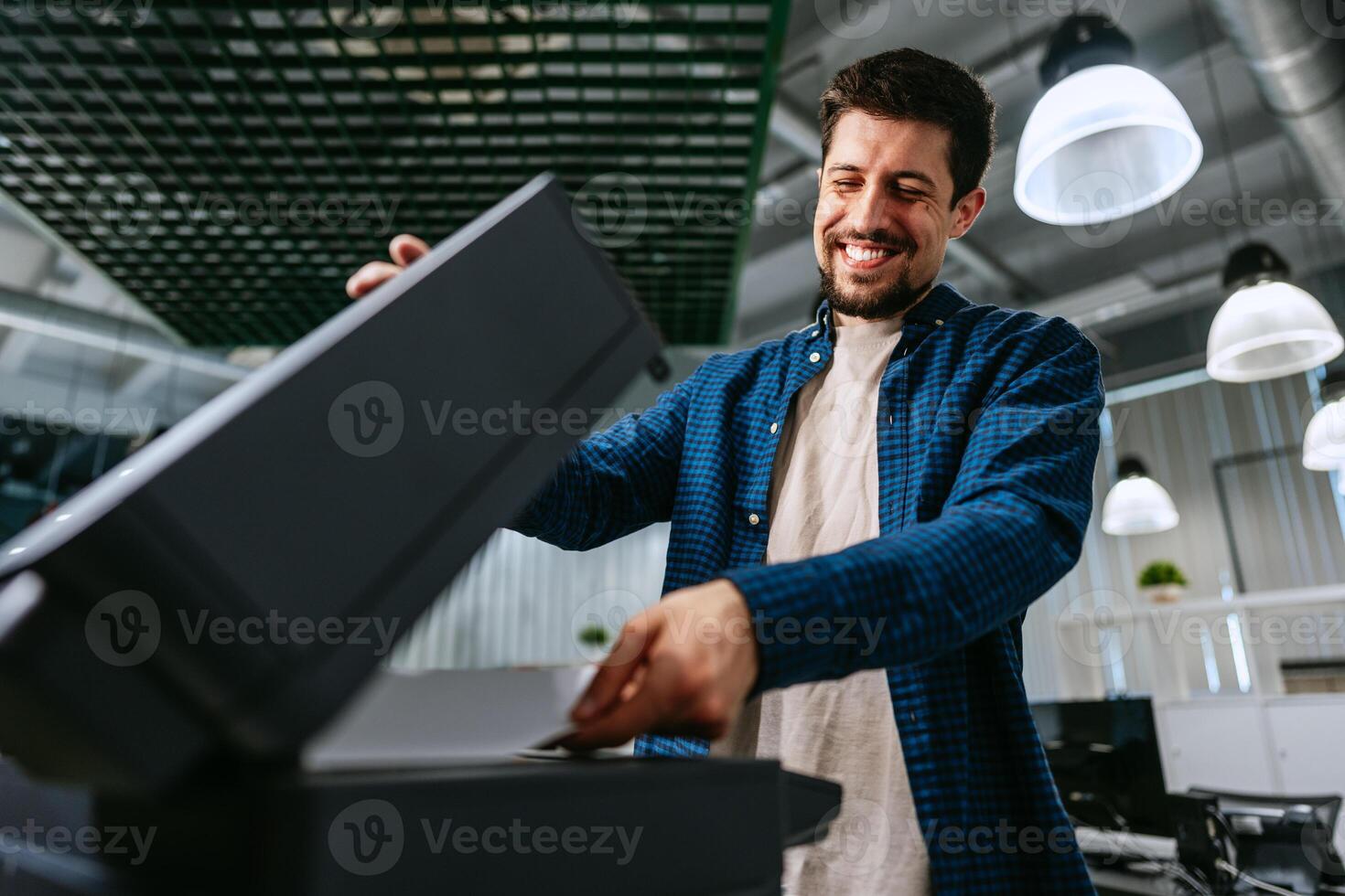 Man operating printer in modern office environment during working hours photo