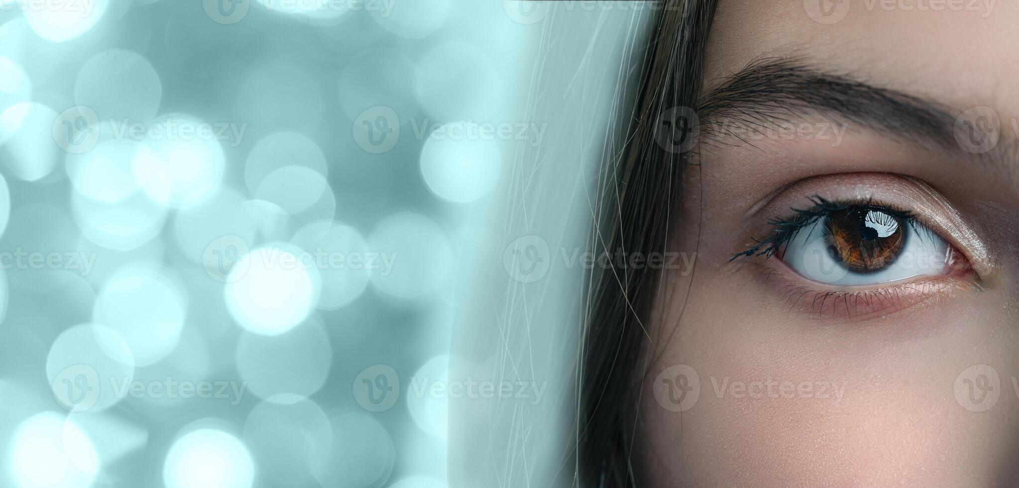 Bright and captivating eye with a unique reflection in a blurred background of sparkling lights photo