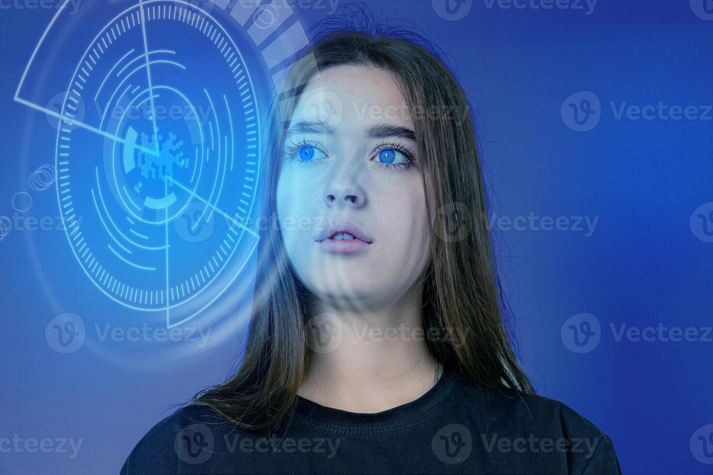 Young woman with blue eyes gazing into futuristic digital interface in a studio setting photo