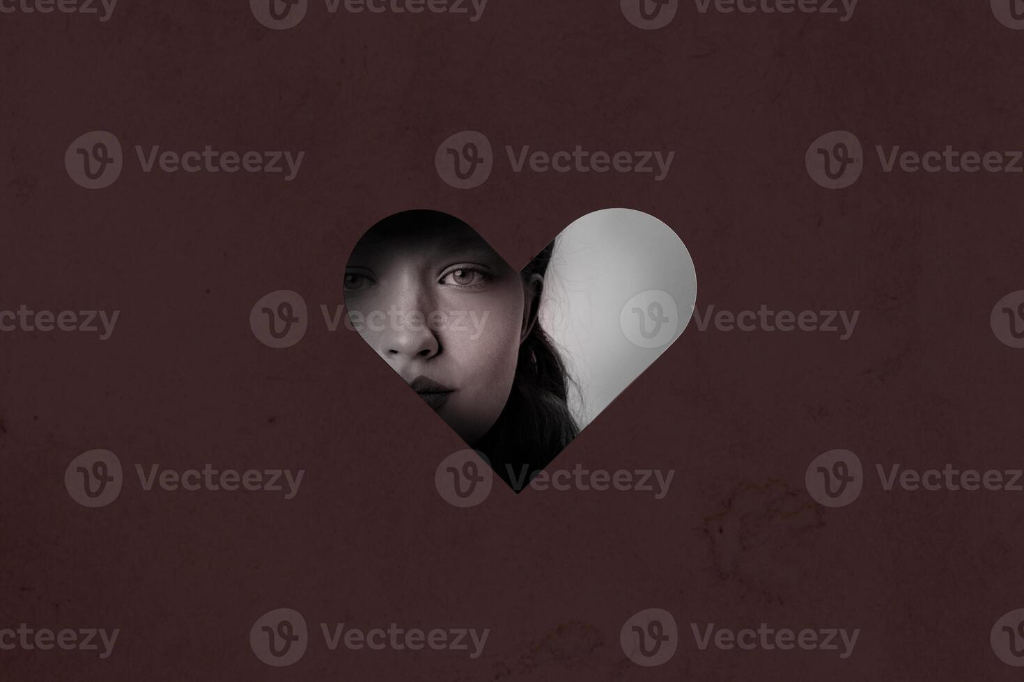 Mysterious gaze through heart-shaped cutout reveals emotions during quiet contemplation photo
