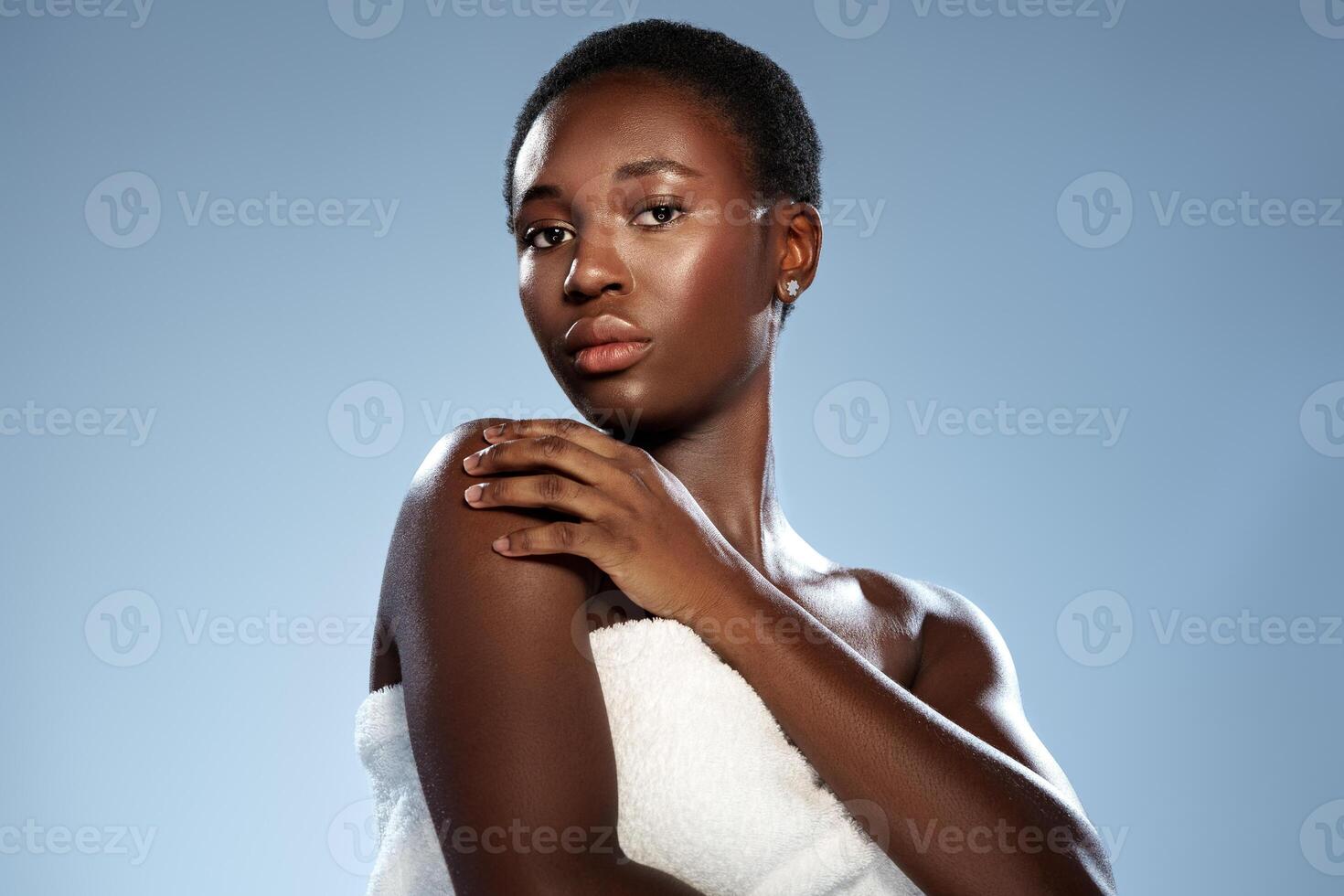 Stunning portrait of a woman with natural beauty showcasing confidence and elegance against a soft blue background photo