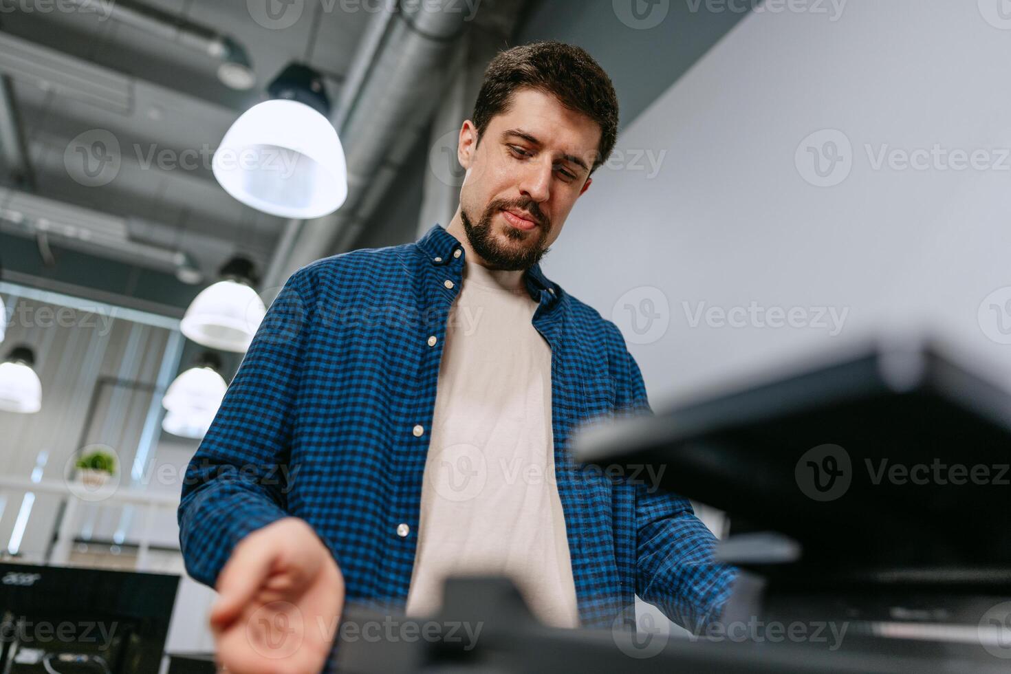 Man working on modern technology in a contemporary office environment during daytime hours photo