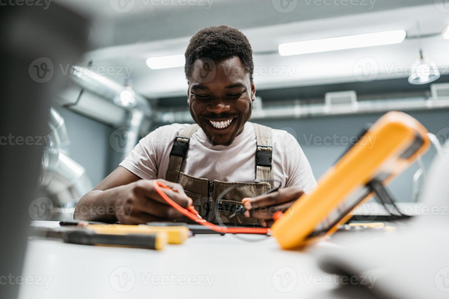 Skilled technician working with tools in a workshop environment during the day, showing enthusiasm and focus on the task at hand photo