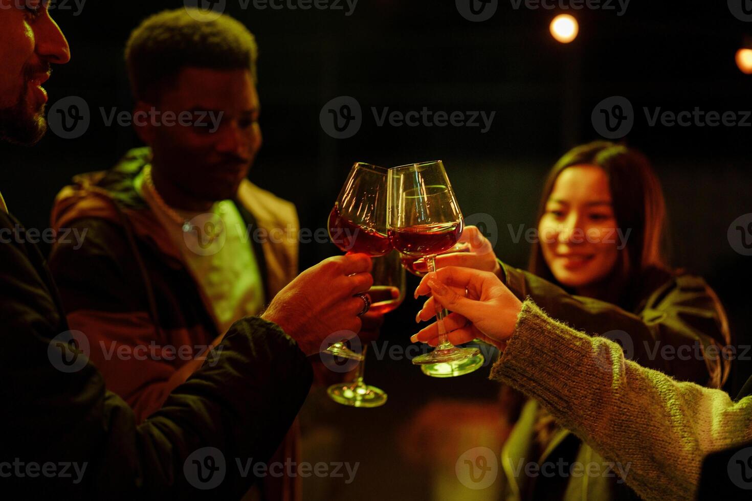 Friends enjoying a lively celebration outdoors while clinking glasses in the evening photo