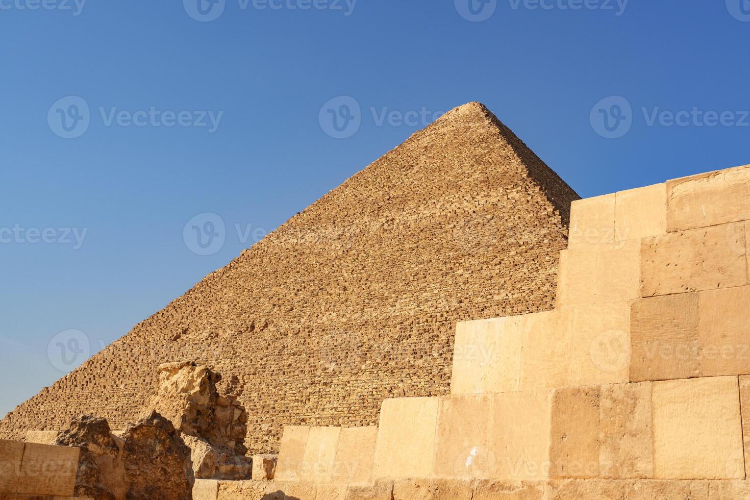 Remarkable view of an ancient pyramid against a clear blue sky in Egypt during midday photo