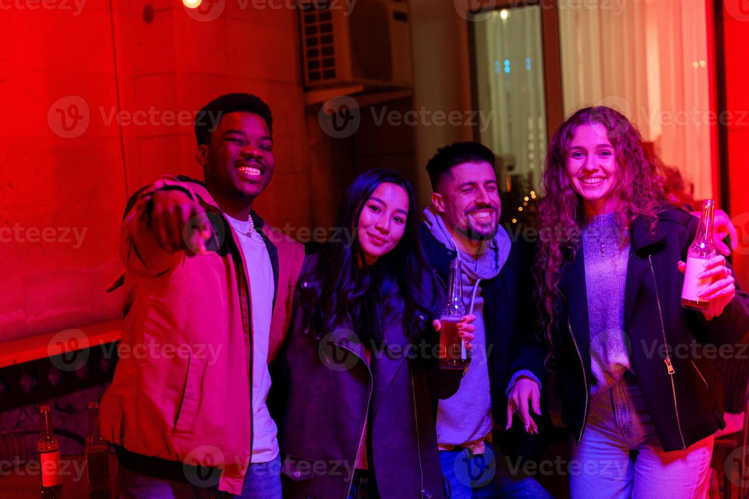 Friends enjoying a vibrant night out in a lively venue with colorful lighting in a city setting photo