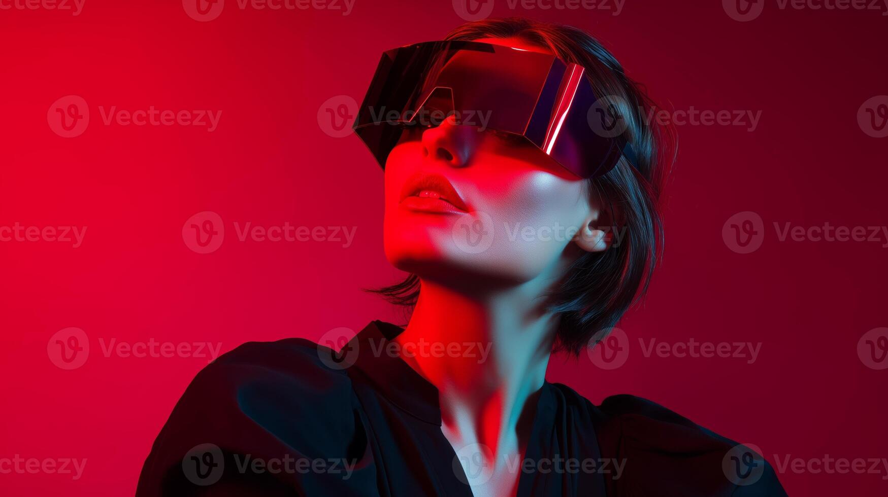 Model poses in futuristic sunglasses with vibrant lighting during a fashion shoot in a studio setting photo
