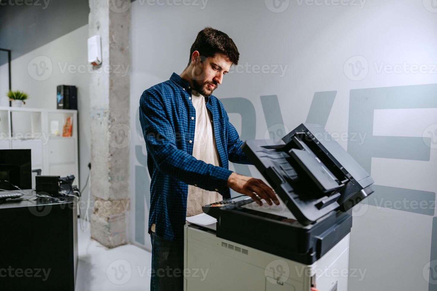 Man using a multifunction printer in a modern office setting during a productive workday photo