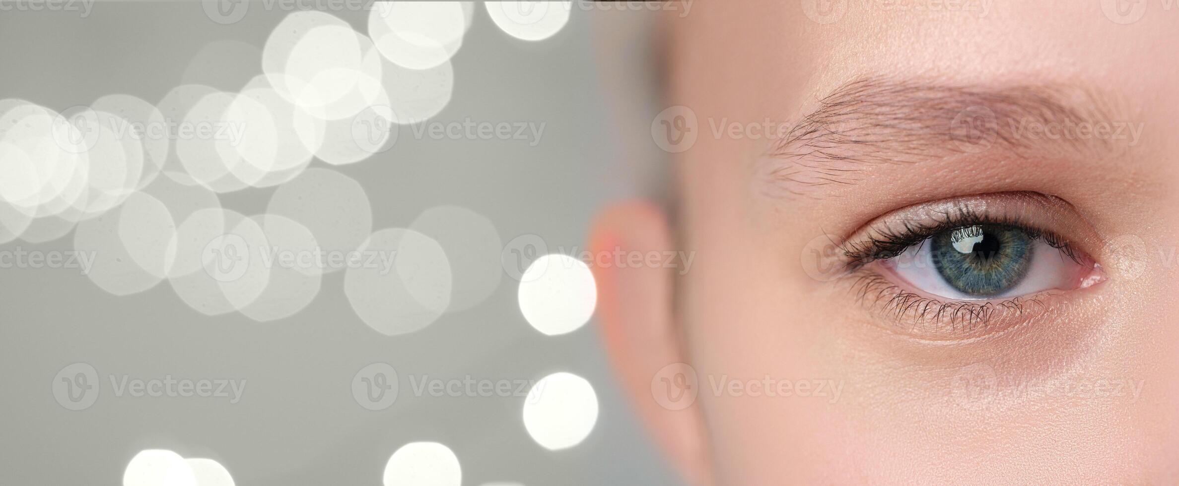 Close-up of a person's eye highlighting unique features and colorful iris against a soft backdrop of blurred lights in a serene setting photo