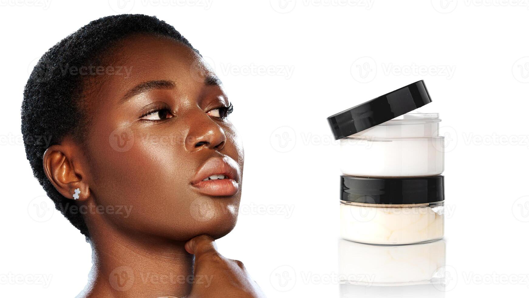 Beautiful woman showcasing clear skin with skincare products in a bright studio during a beauty session photo