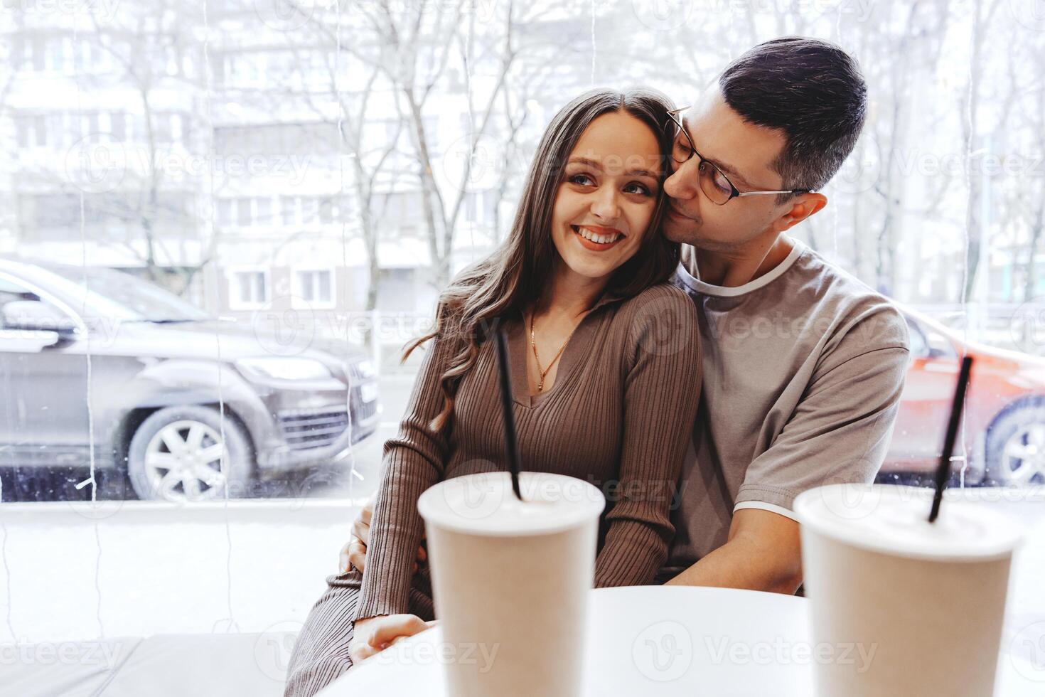 Couple enjoying a cozy moment at a cafe while sipping beverages on a winter day photo
