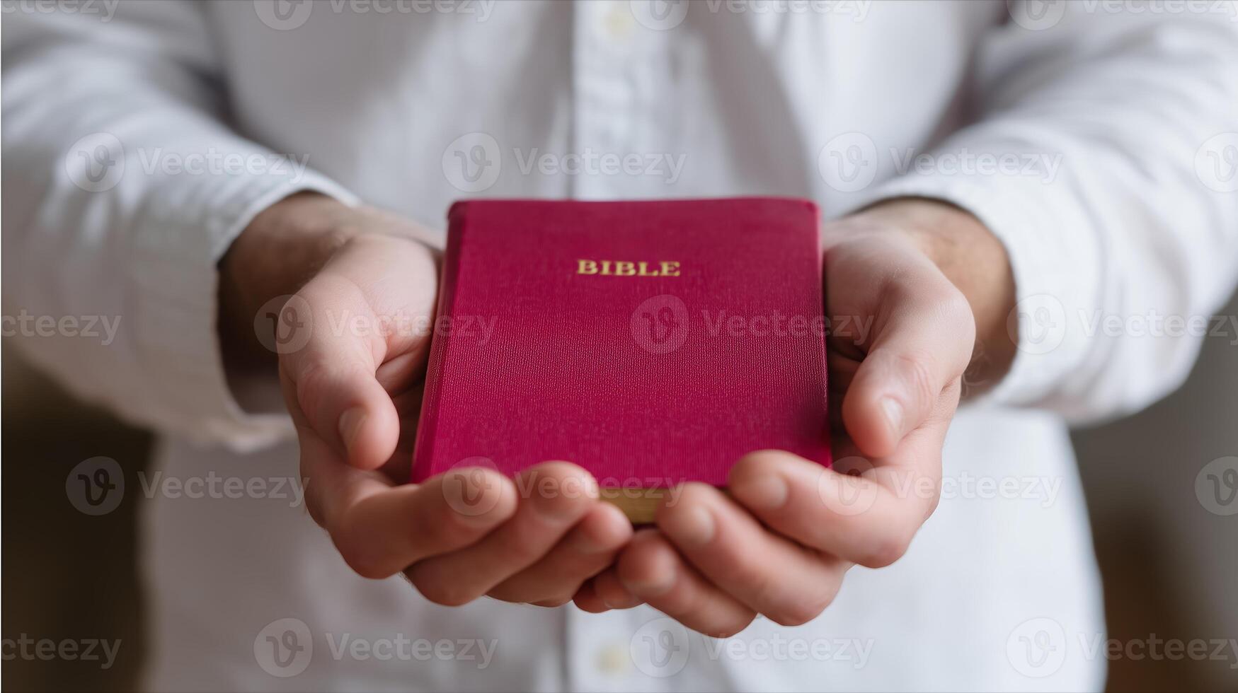 Hands holding a red Bible indoors during a quiet moment of reflection or prayer photo