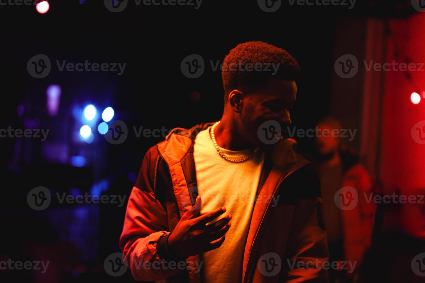 Vibrant night scene with a man enjoying music at a live event in a contrasting lit venue photo