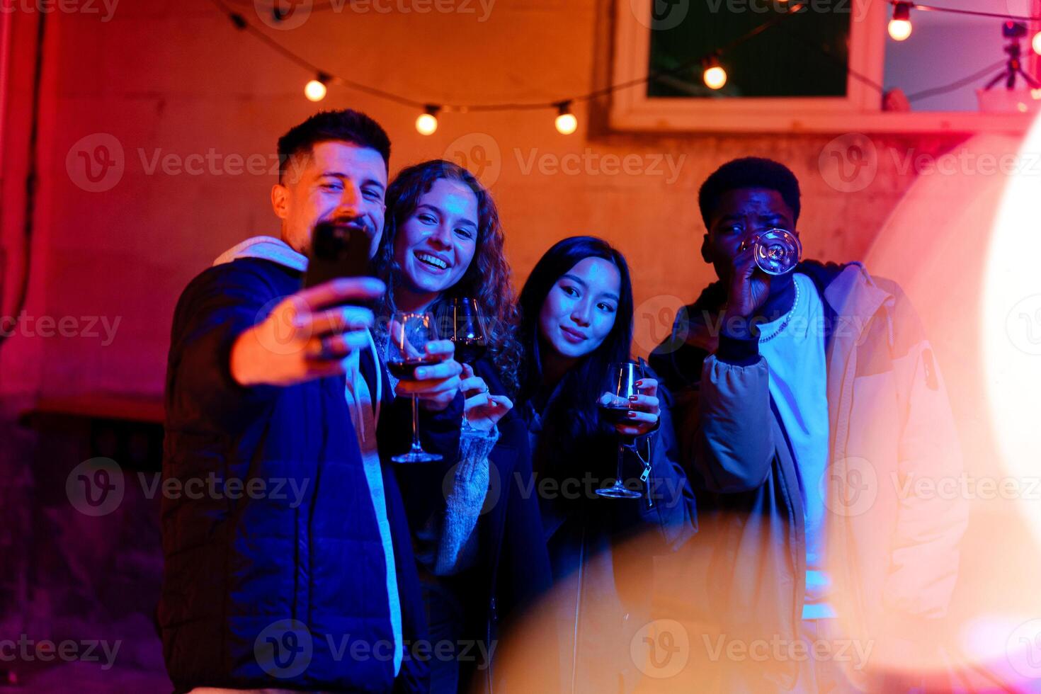 Friends celebrating with drinks in a vibrant outdoor setting during the evening hours photo
