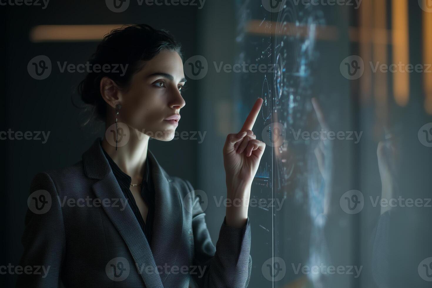 Professional woman interacts with digital interface in a modern workspace during evening hours photo