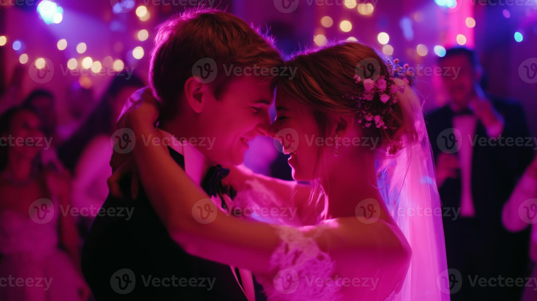 Couple dances joyfully at a wedding reception under vibrant lights and decorations in an elegant venue photo