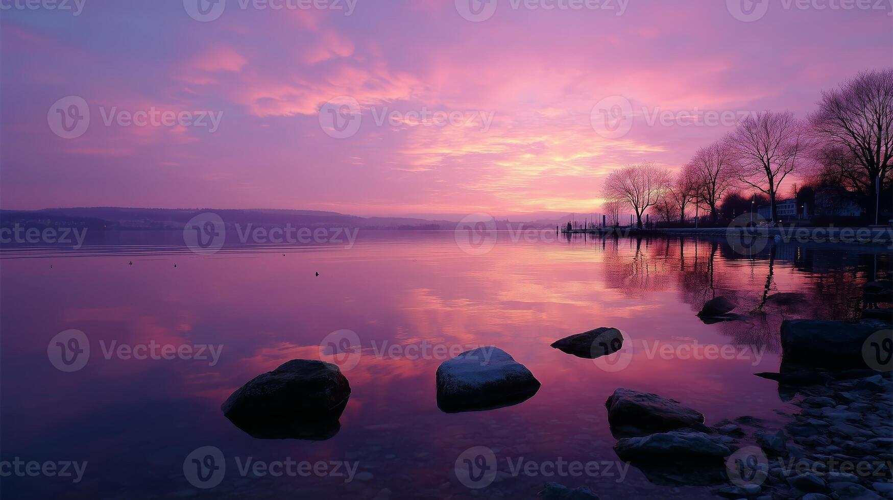 Vibrant sunset over tranquil lake with silhouetted trees and smooth water reflections photo
