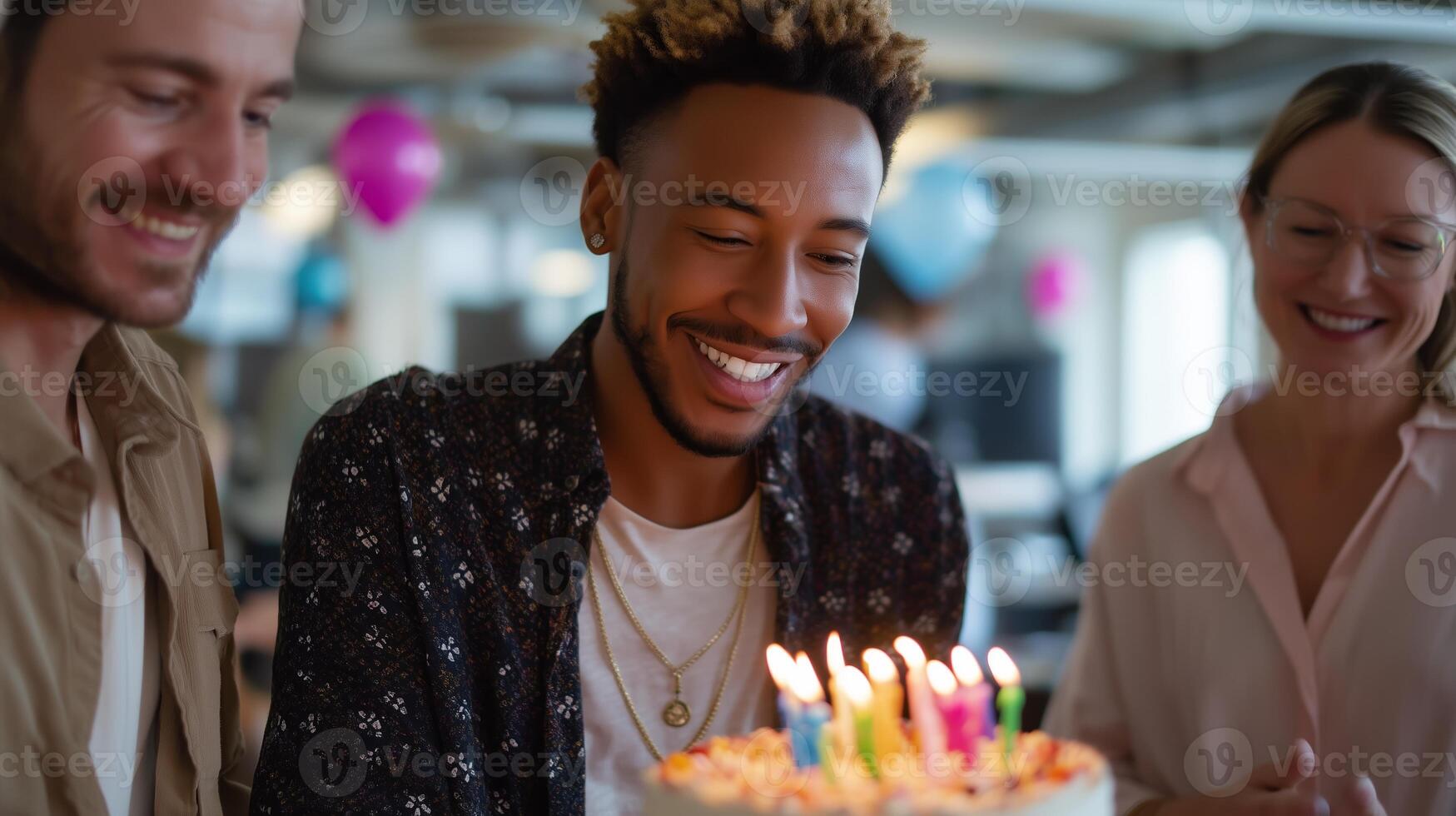 Friends celebrate a birthday with a cake and candles in a cheerful office environment during a festive gathering photo