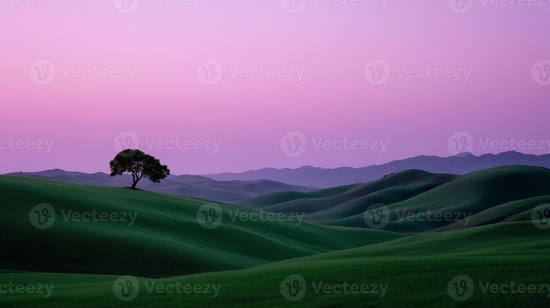 Sunset over rolling hills with a solitary tree in a serene landscape photo