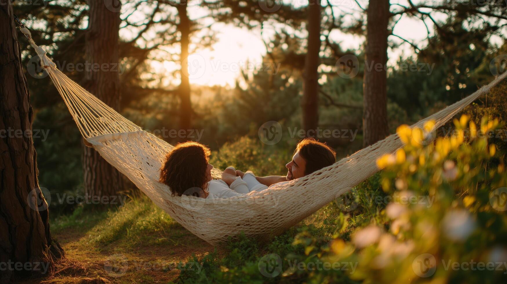 Relaxing time in a hammock at sunset with friends surrounded by nature photo