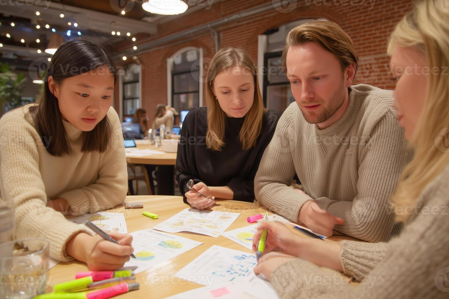 Collaboration among four young professionals in a modern workspace focused on creative brainstorming photo