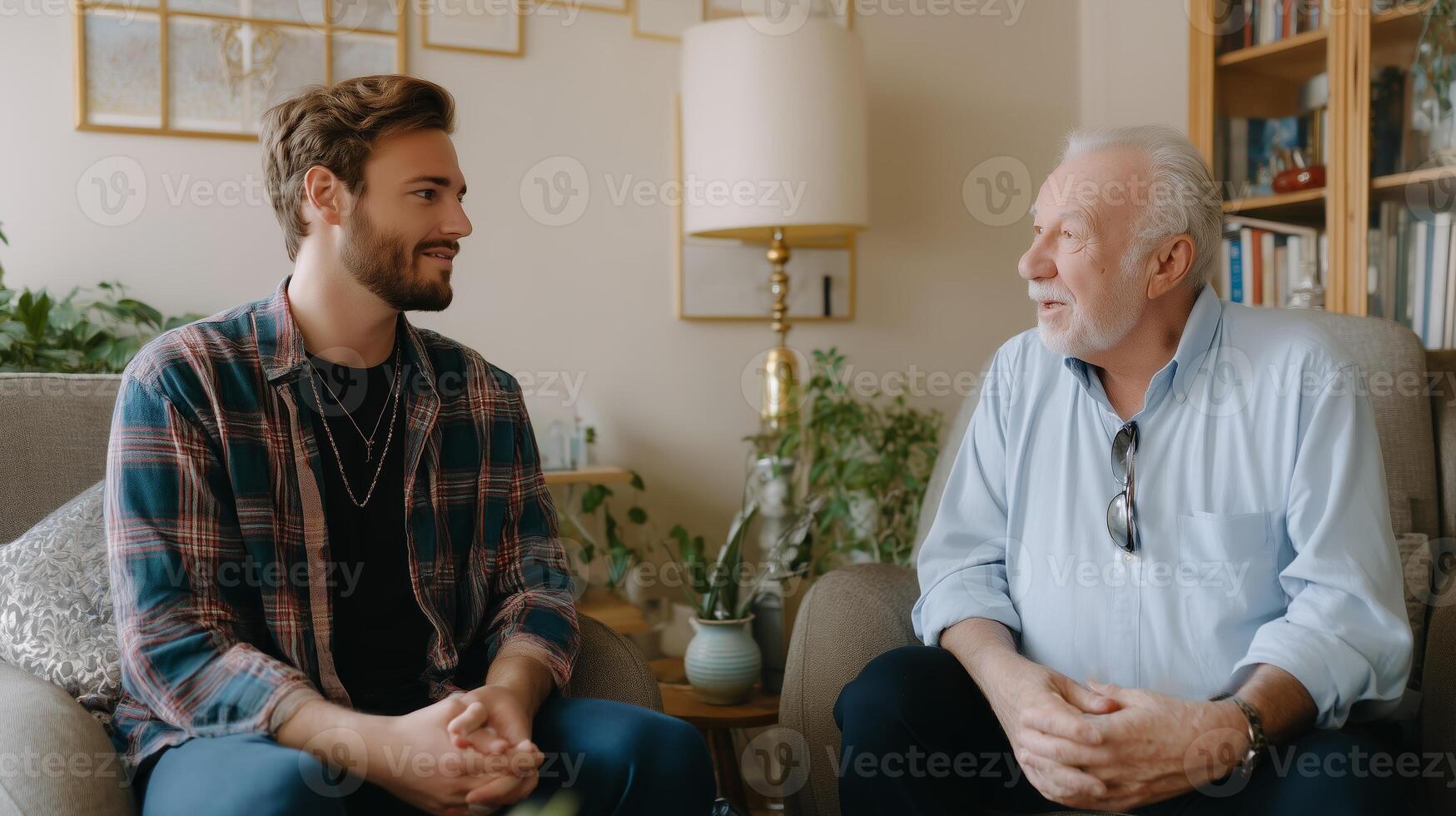 Young man and older gentleman having a conversation in a cozy living room filled with plants photo