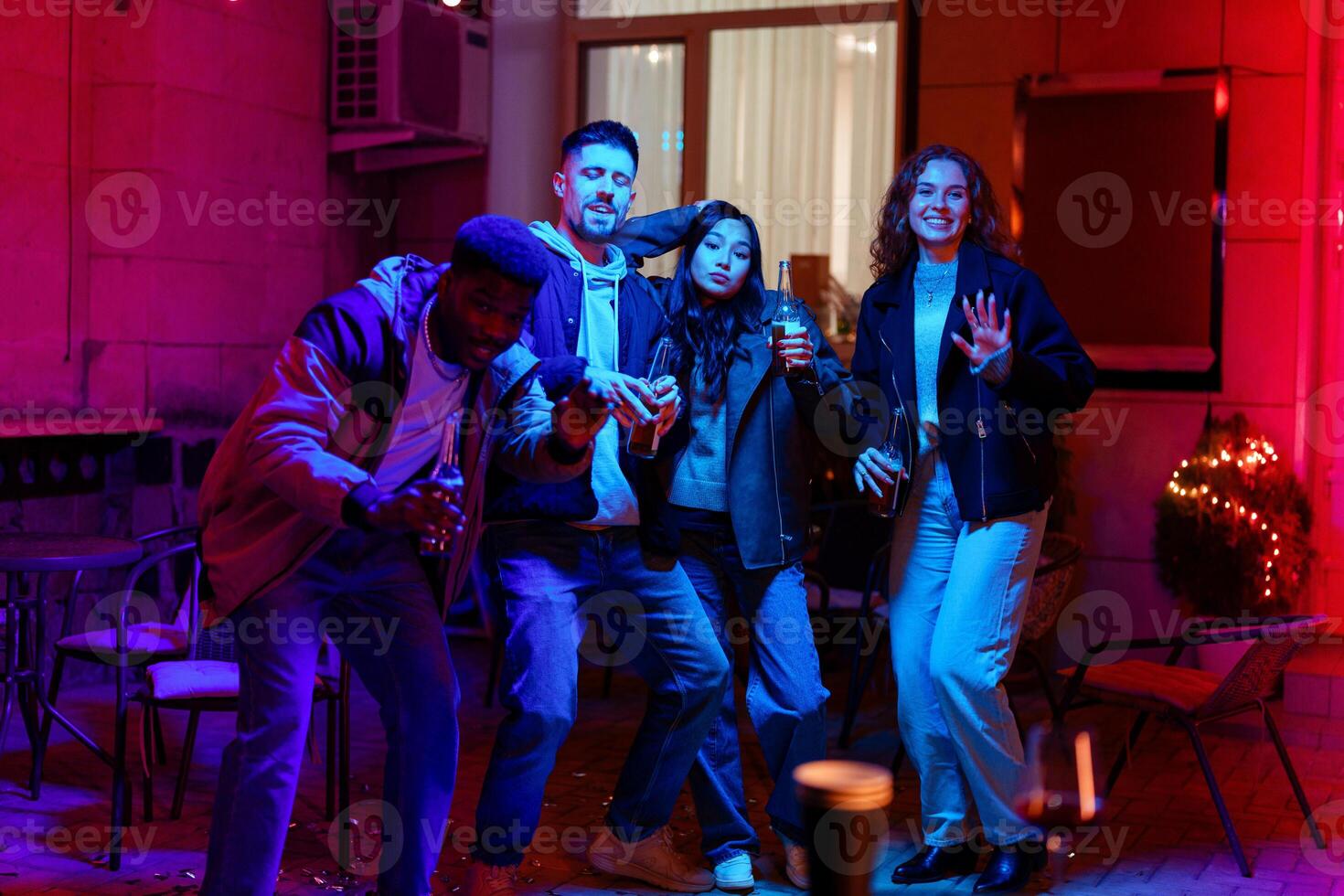 Friends enjoying a lively party with colorful lights and drinks on a festive evening photo