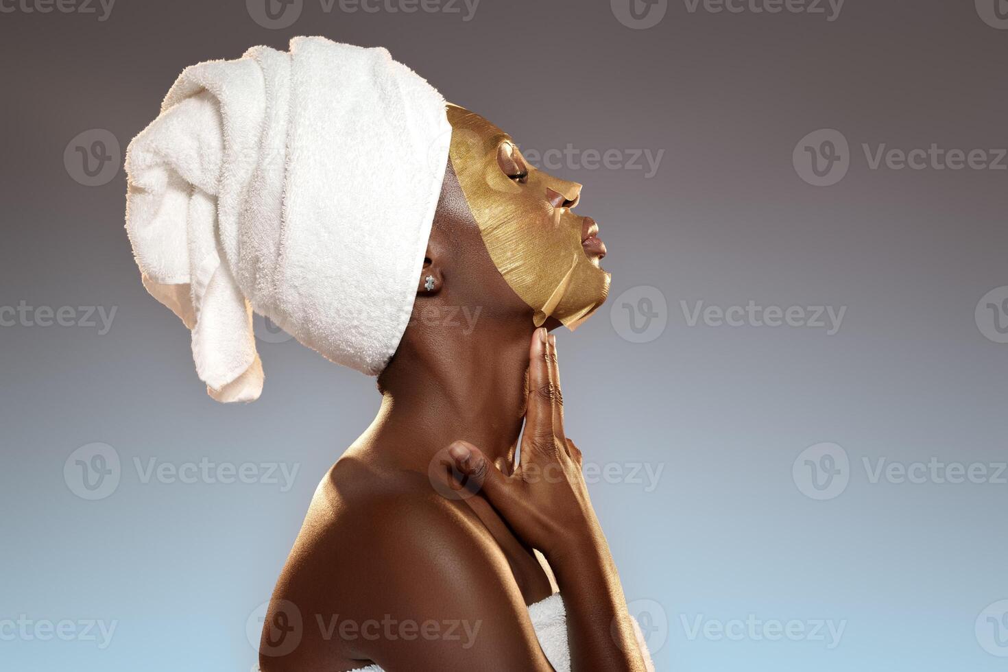 Relaxing skin treatment session featuring a woman applying a golden face mask in a serene setting photo