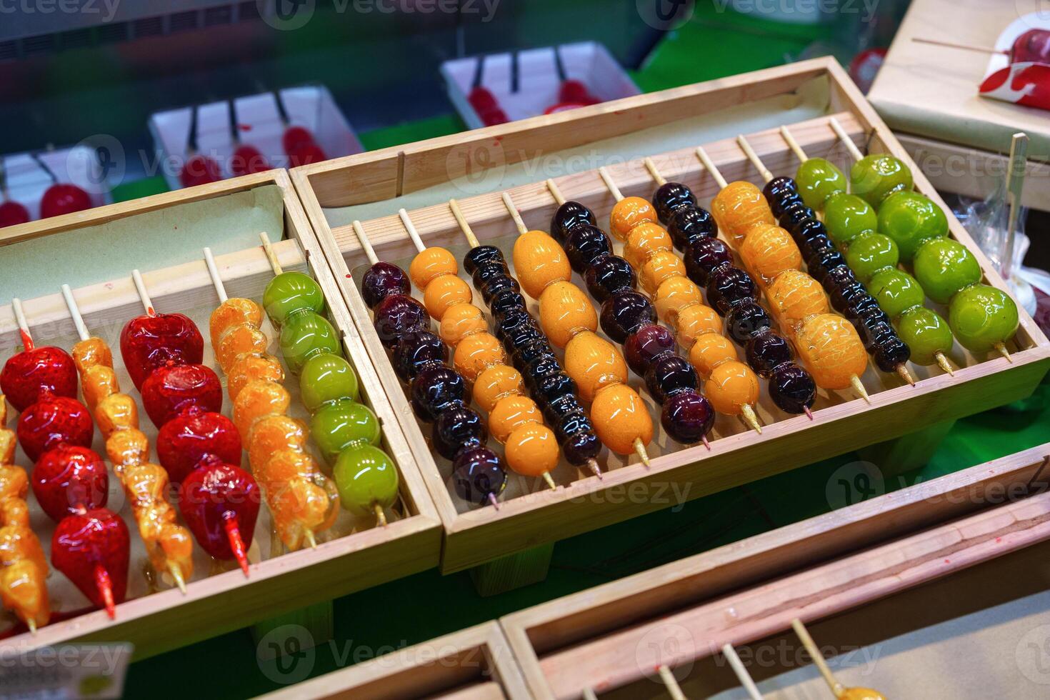 Delicious dessert skewers displayed at a bustling market during an evening food festival photo