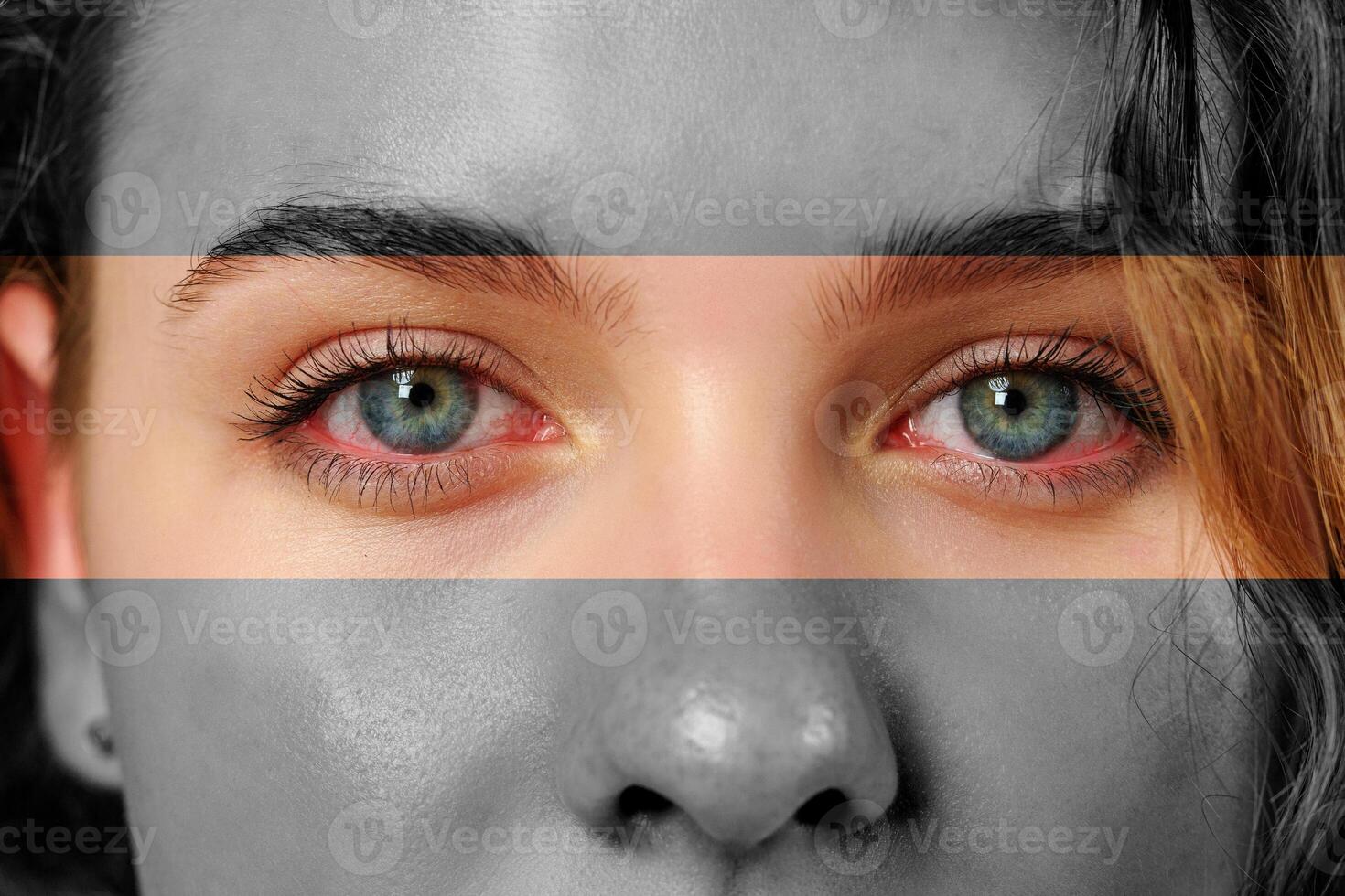 Close-up portrait of a person with striking blue eyes and grayscale effects in a creative artistic representation photo
