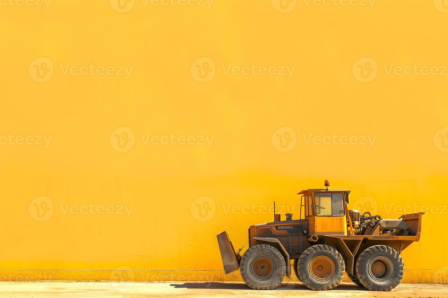 A yellow construction vehicle parked in front of a wall photo