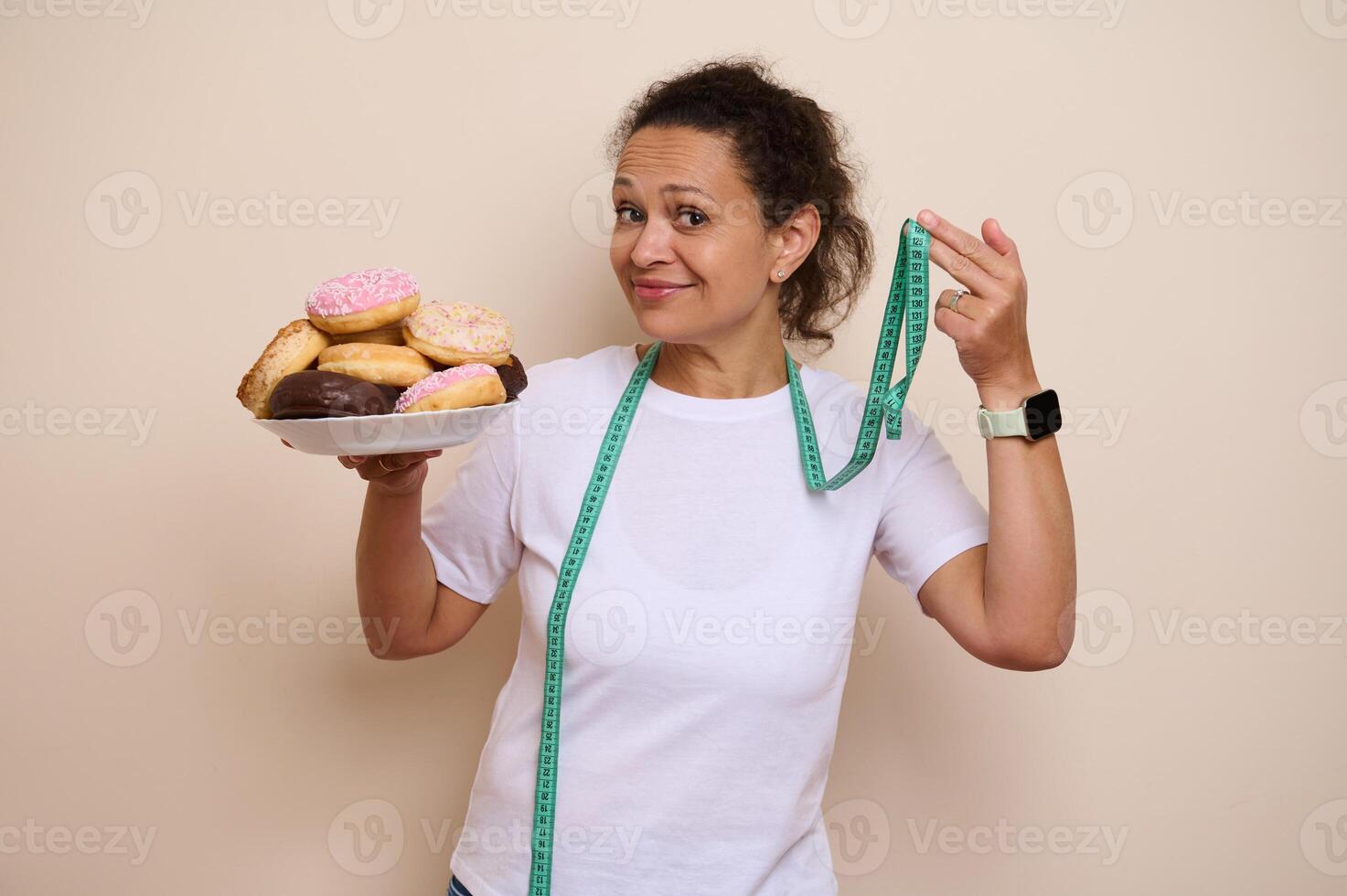 Woman Balancing Healthy Choices and Indulgence with Plate of Doughnuts and Measuring Tape photo