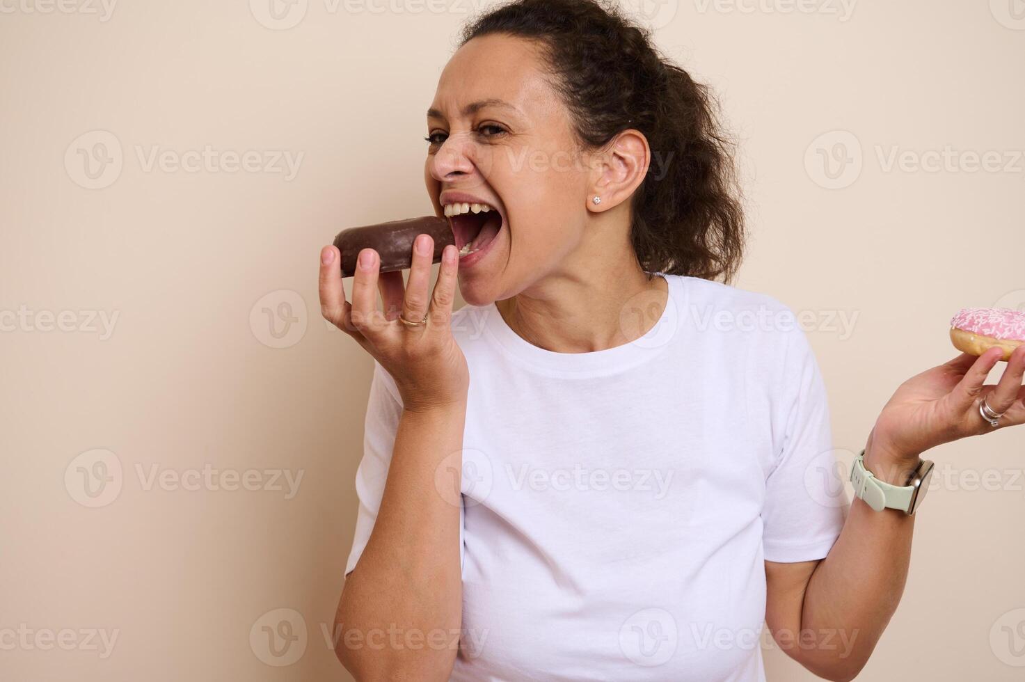 Woman Happily Enjoying Doughnuts in a Playful Pose photo