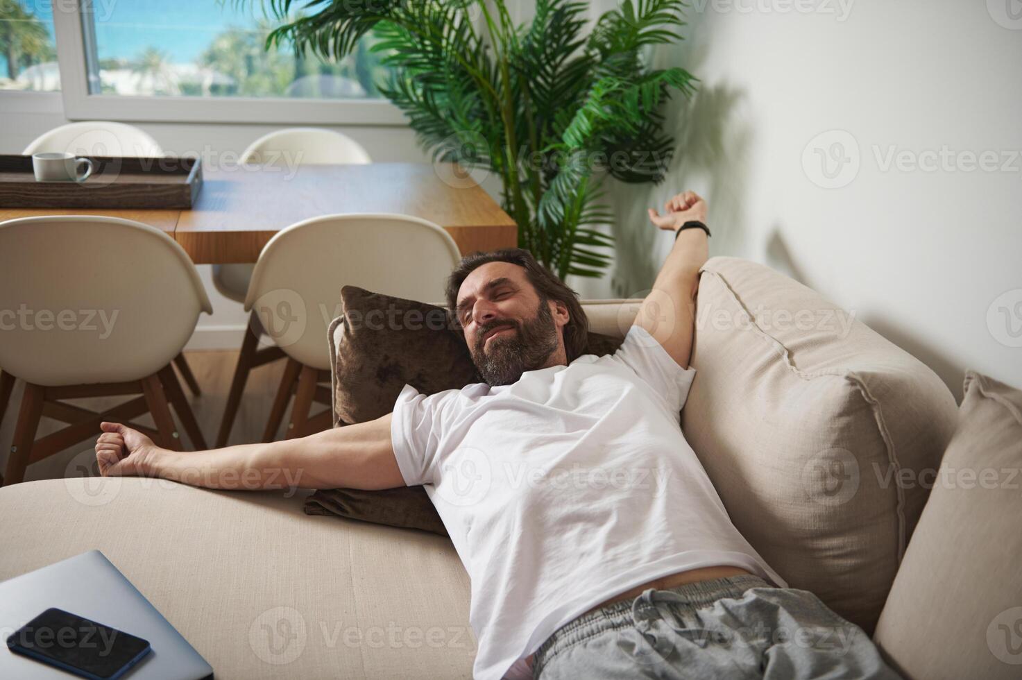Man Relaxing on a Comfortable Couch in a Minimalist Home Setting photo