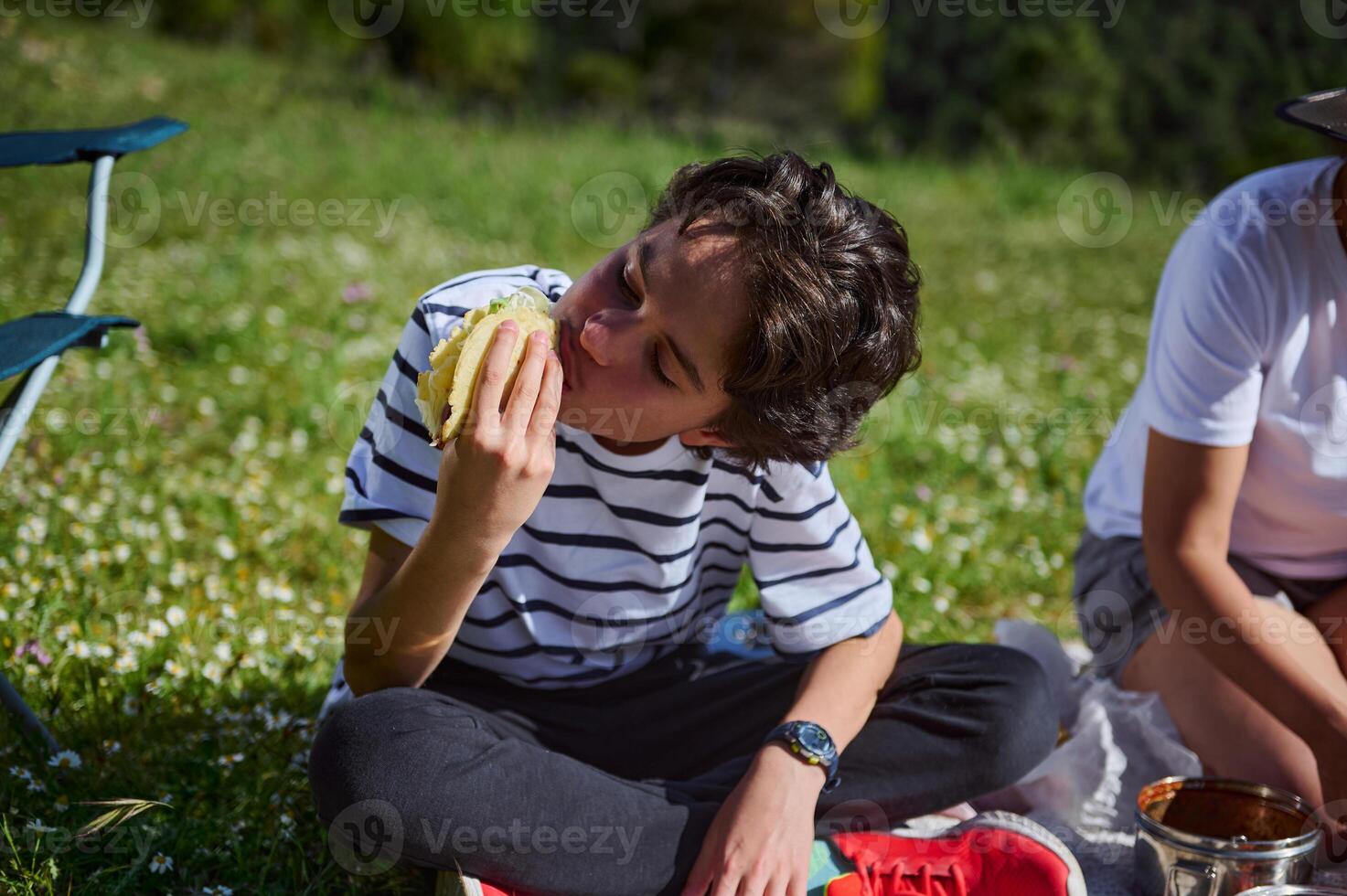 Family Enjoying a Picnic in Nature With Fresh Tacos on a Sunny Day photo