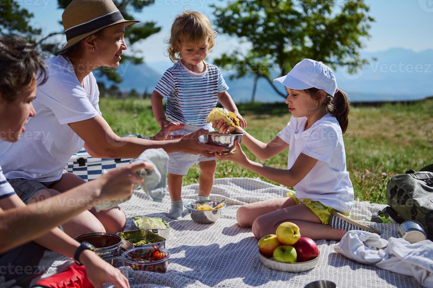 Family Enjoying a Summer Picnic in the Mountains Sharing Tacos on a Sunny Day with Scenic Landscape Views photo