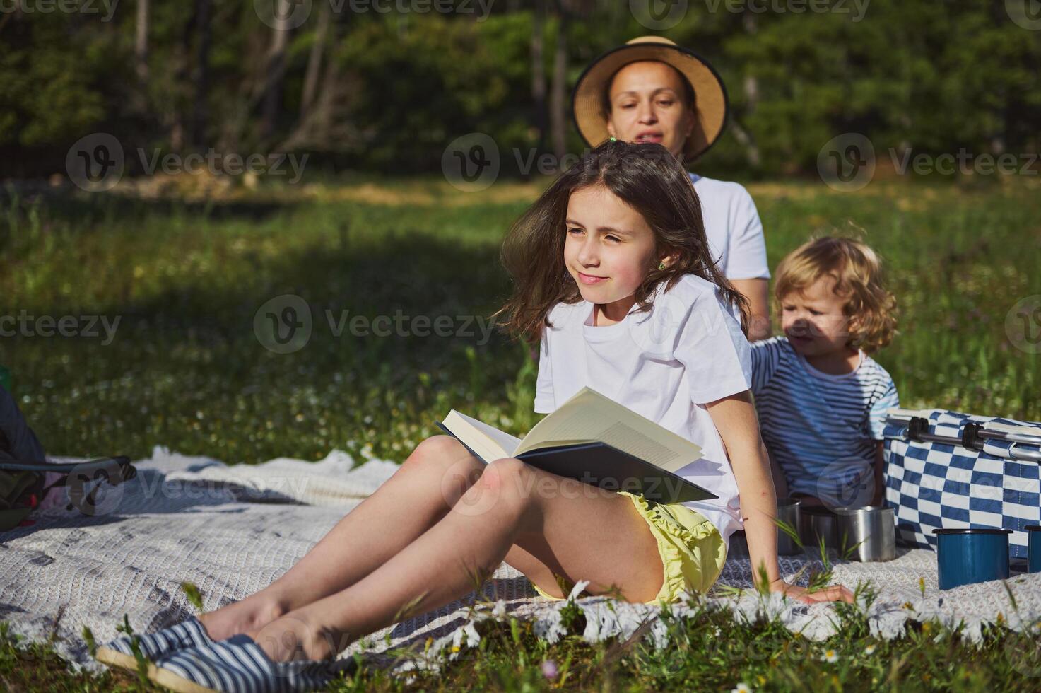 Family Enjoying a Relaxing Outdoor Picnic with Nature Background Under Sunny Skies photo