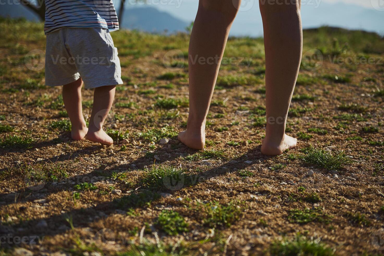 Barefoot Bonding Moment Outdoors Between Adult and Toddler photo
