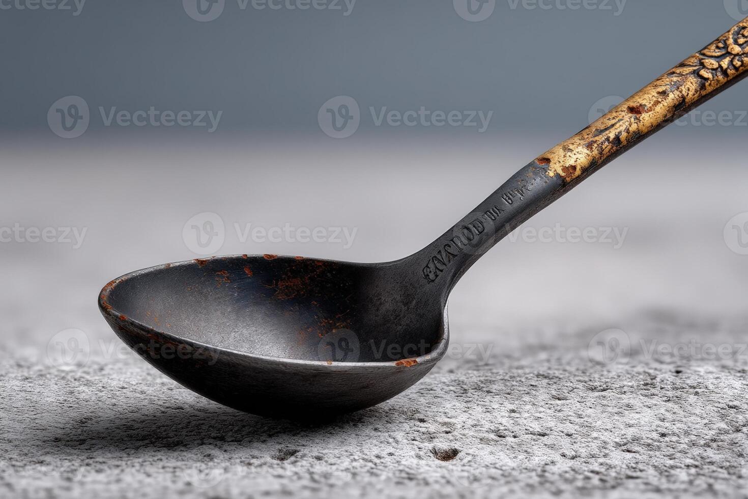 Unique antique spoon on textured surface with visible rust and patina photo