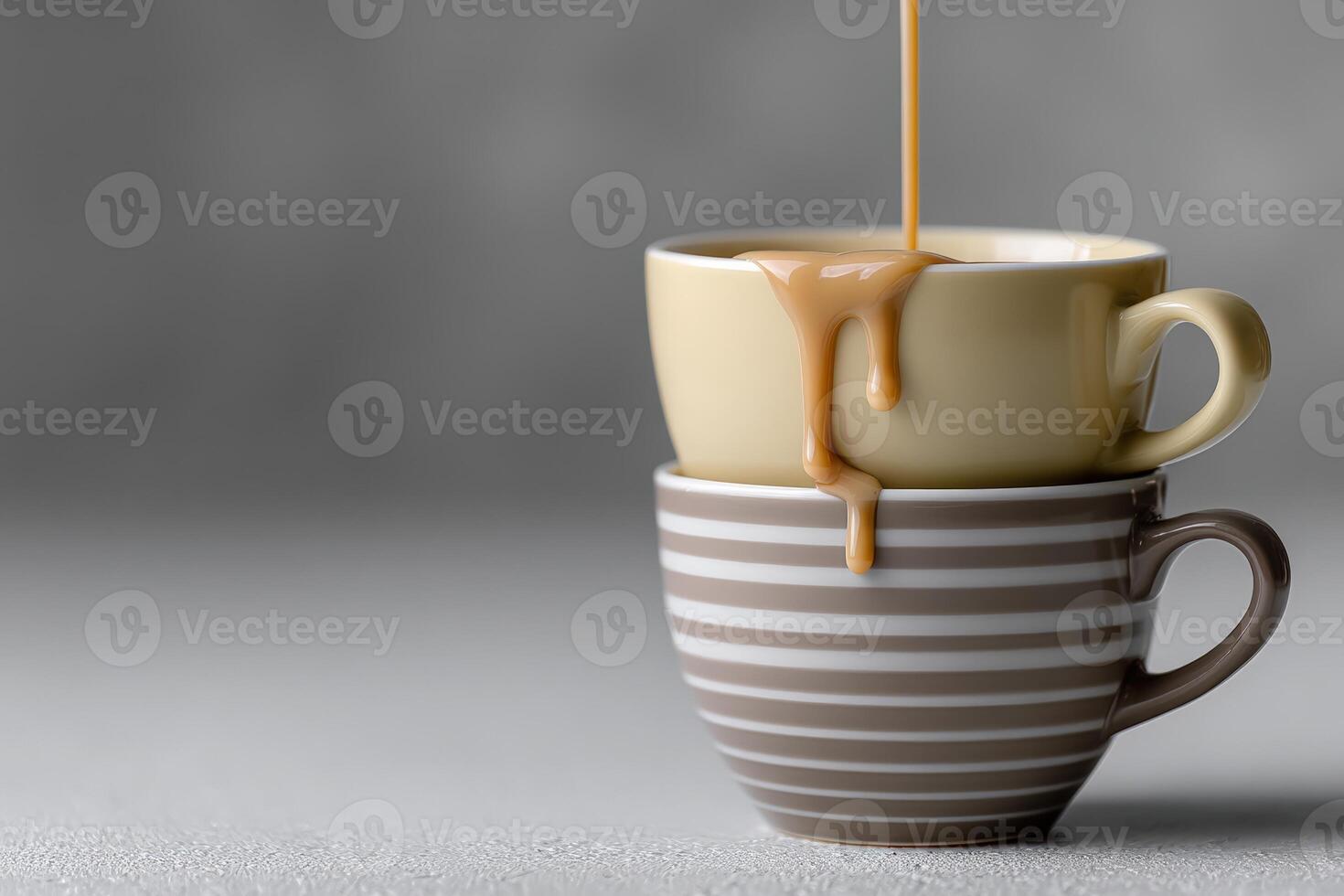 Coffee being poured into stacked cups on a simple gray background photo