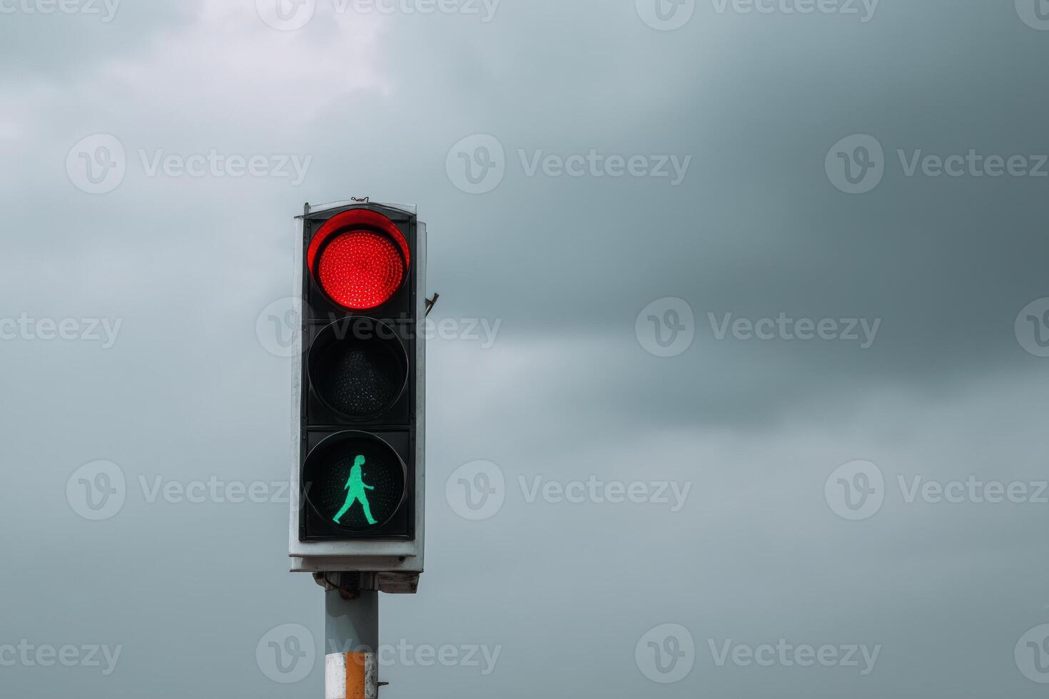 Traffic light displaying red and green signals with cloudy sky in the background photo