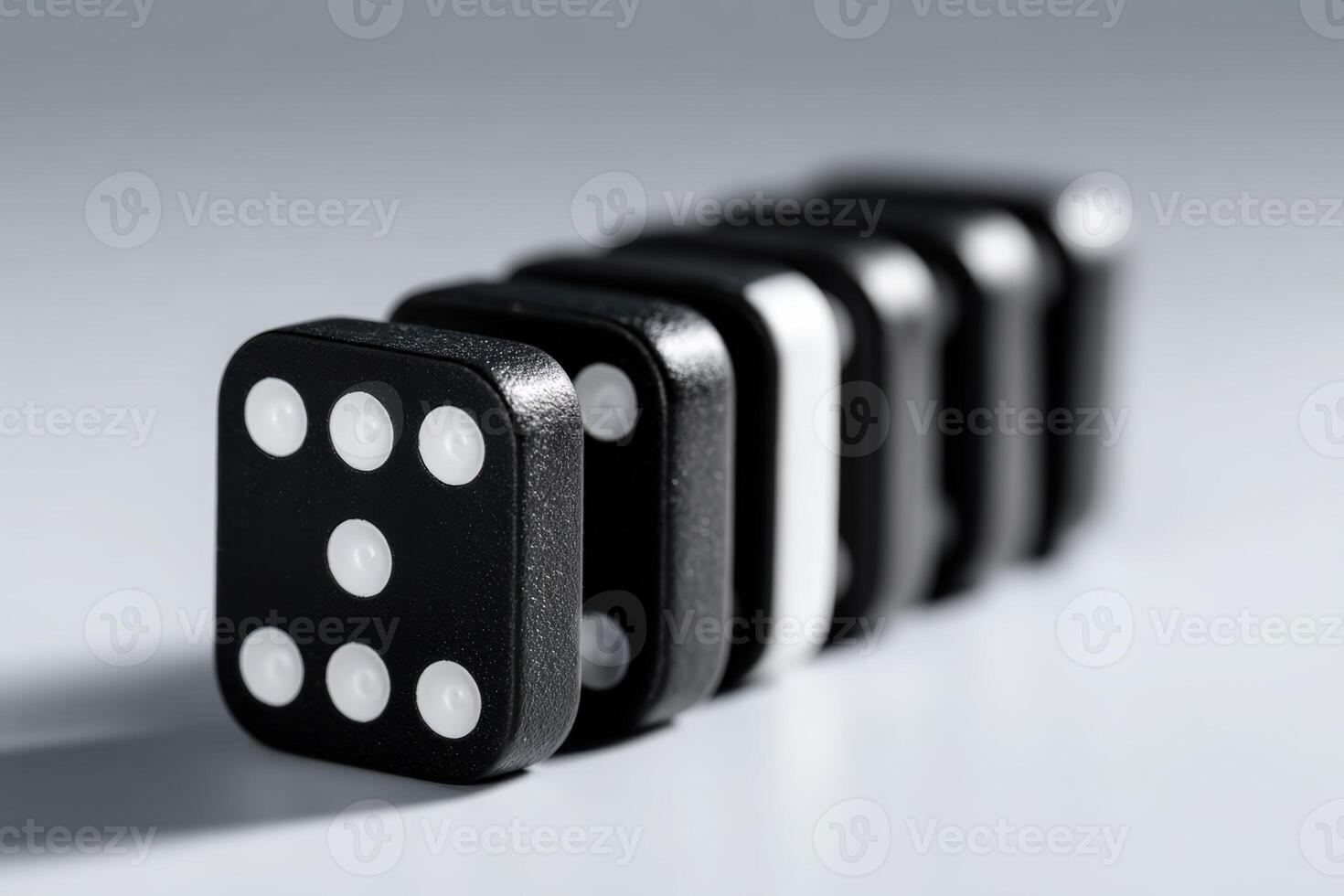 Classic black and white dominoes lined up in a creative arrangement on a white surface photo