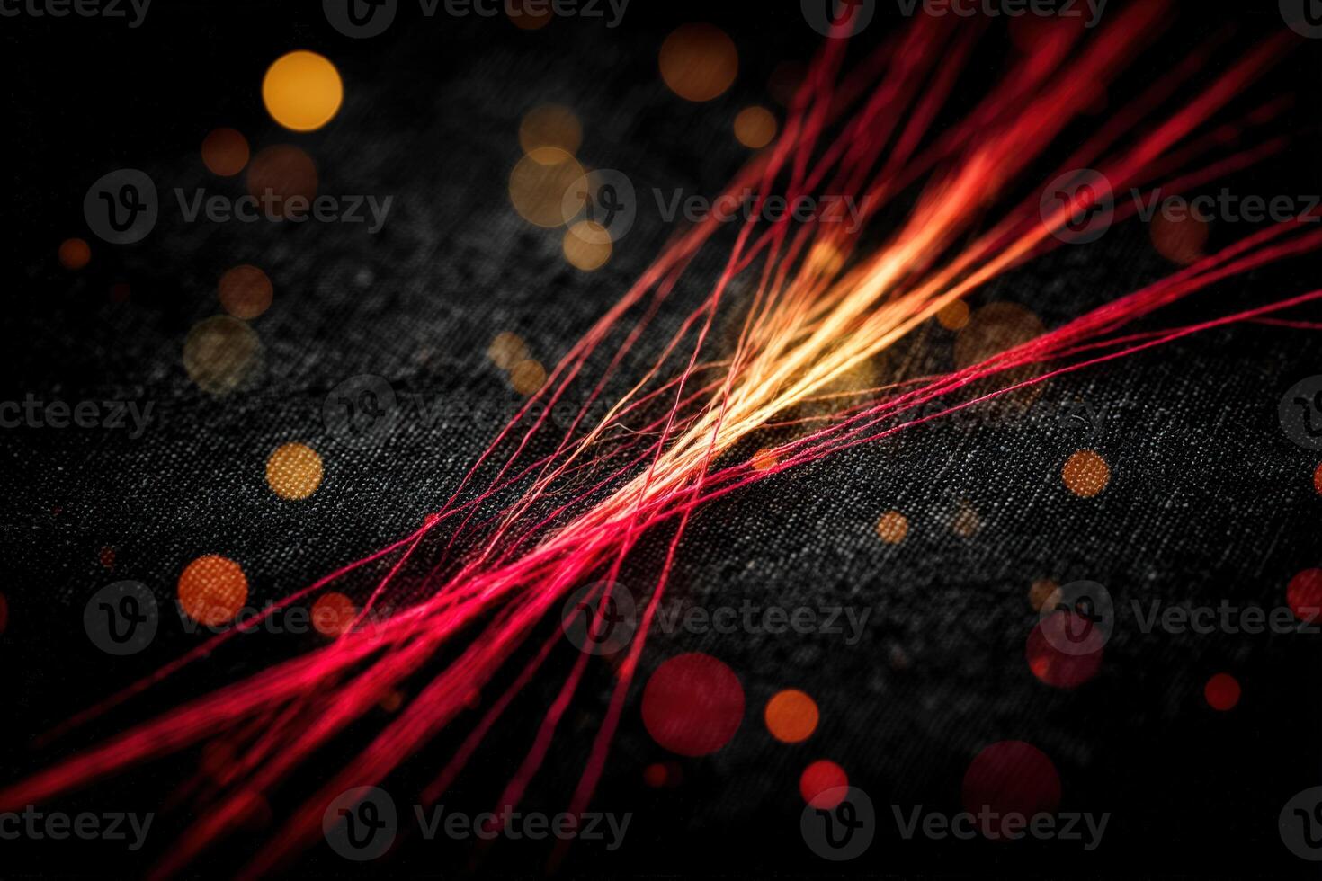 Vibrant strands of red and orange threads create an artistic display on dark fabric photo