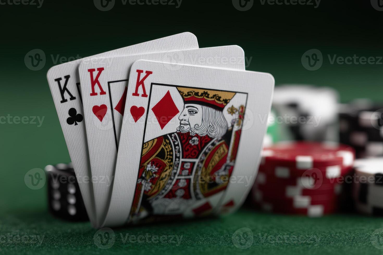 Three kings in a card game on a green felt table with poker chips nearby photo
